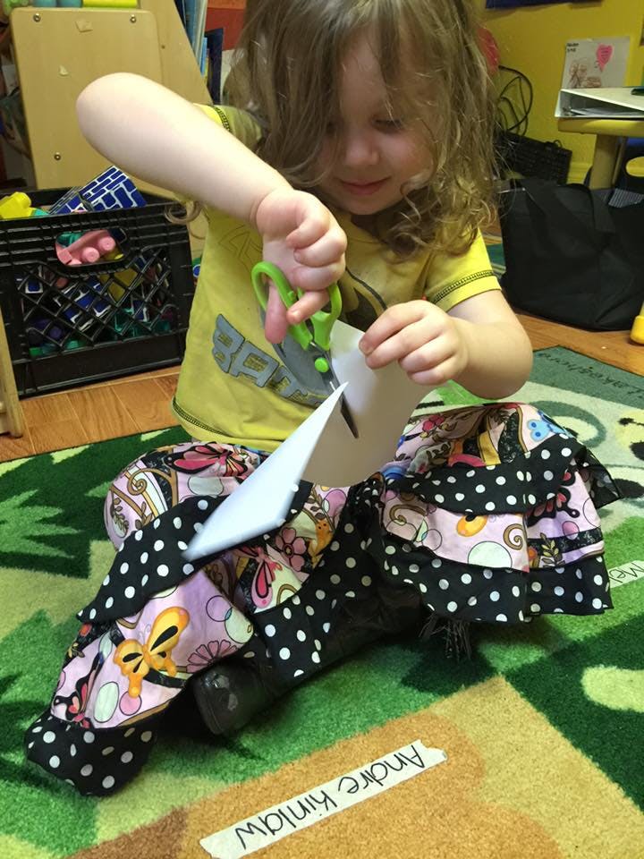 Child cutting paper with scissors