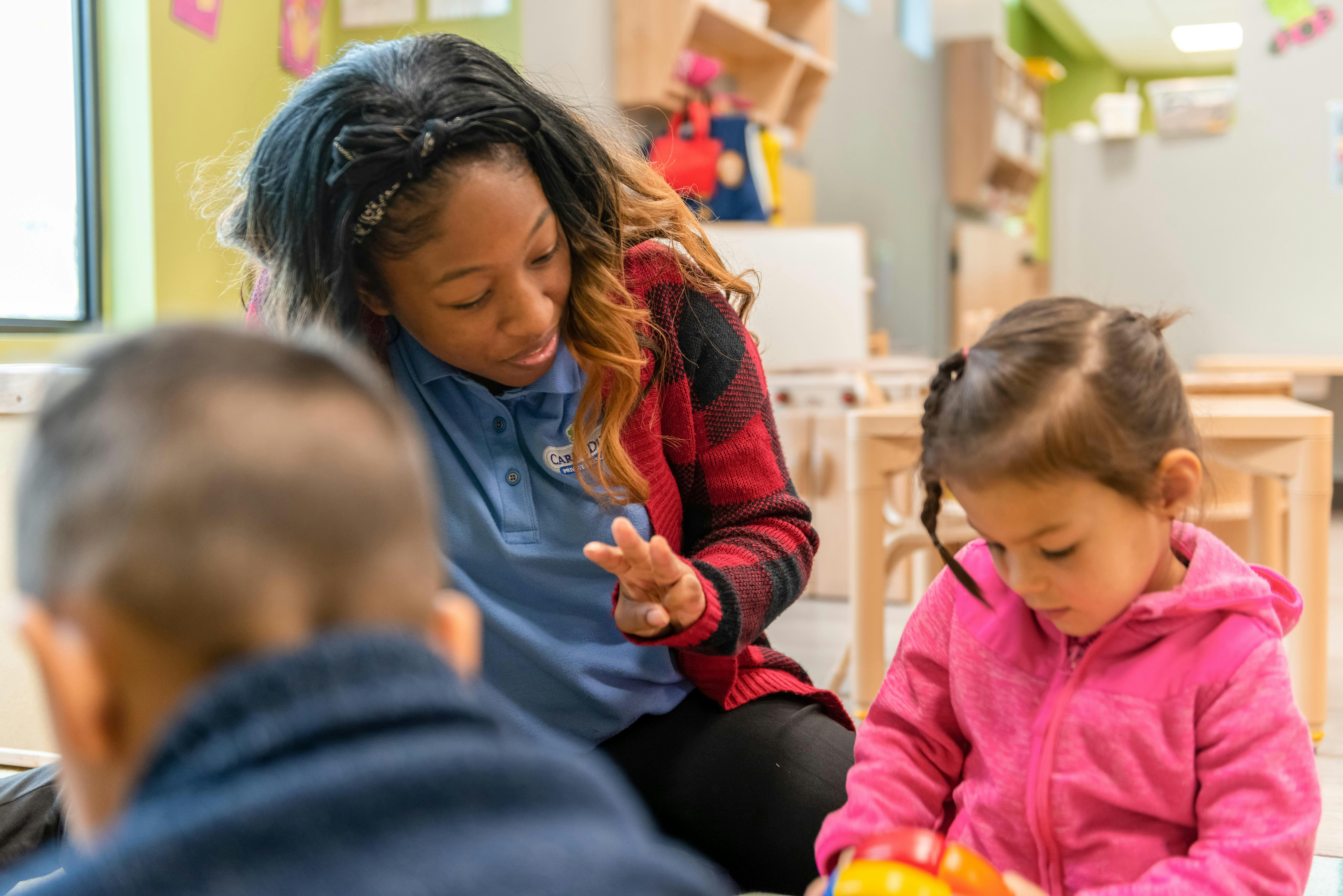 Person interacting with a child in a classroom