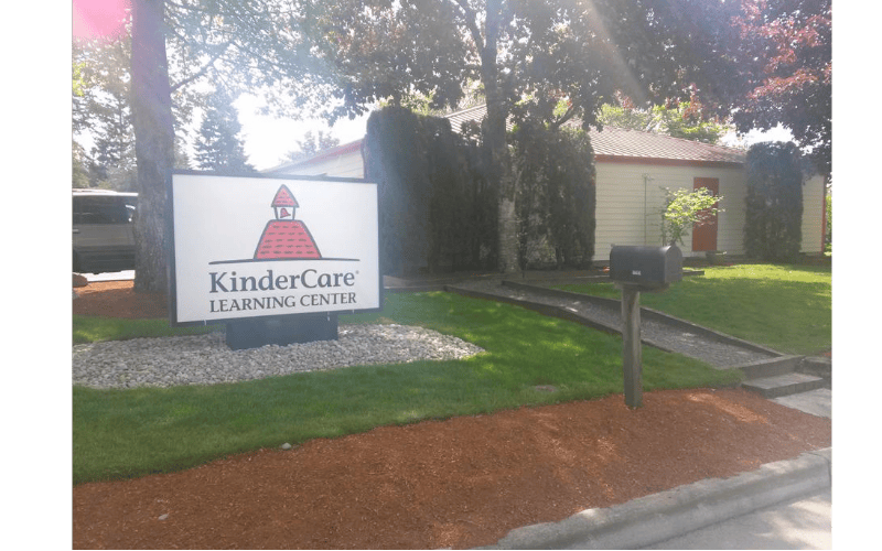 KinderCare Learning Center sign in front of a building with a red door
