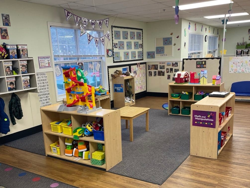 A colorful playroom with toys, activity centers, and children's artwork on the walls