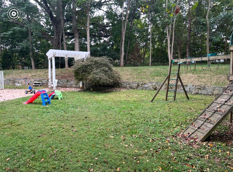 Backyard with a swing set, slide, and small play structures
