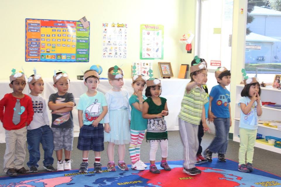 Children in a classroom wearing paper hats