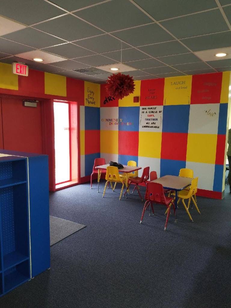 Classroom with colorful checkered walls, small tables, and chairs