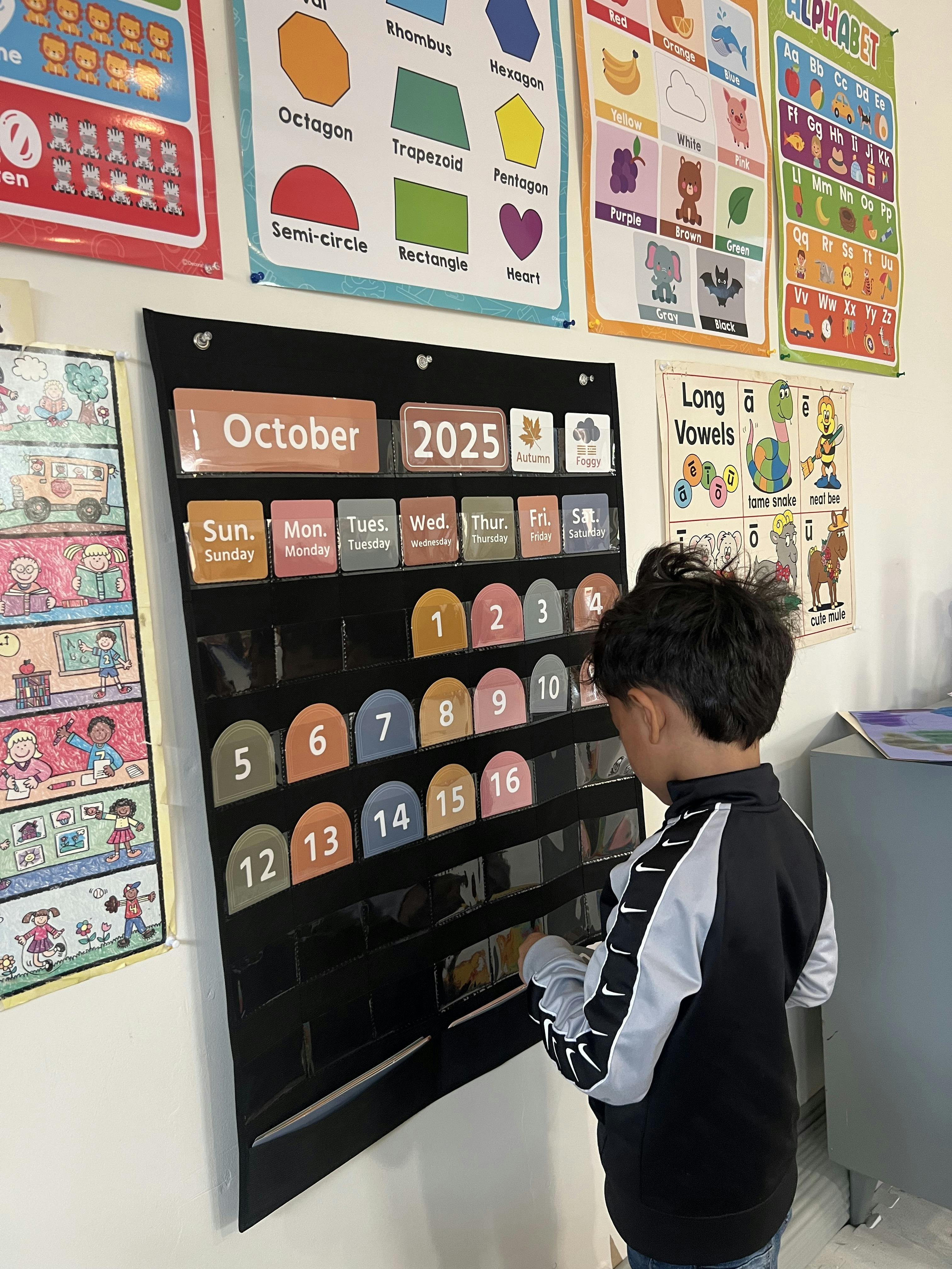 Child placing a number into a pocket calendar for October 2025