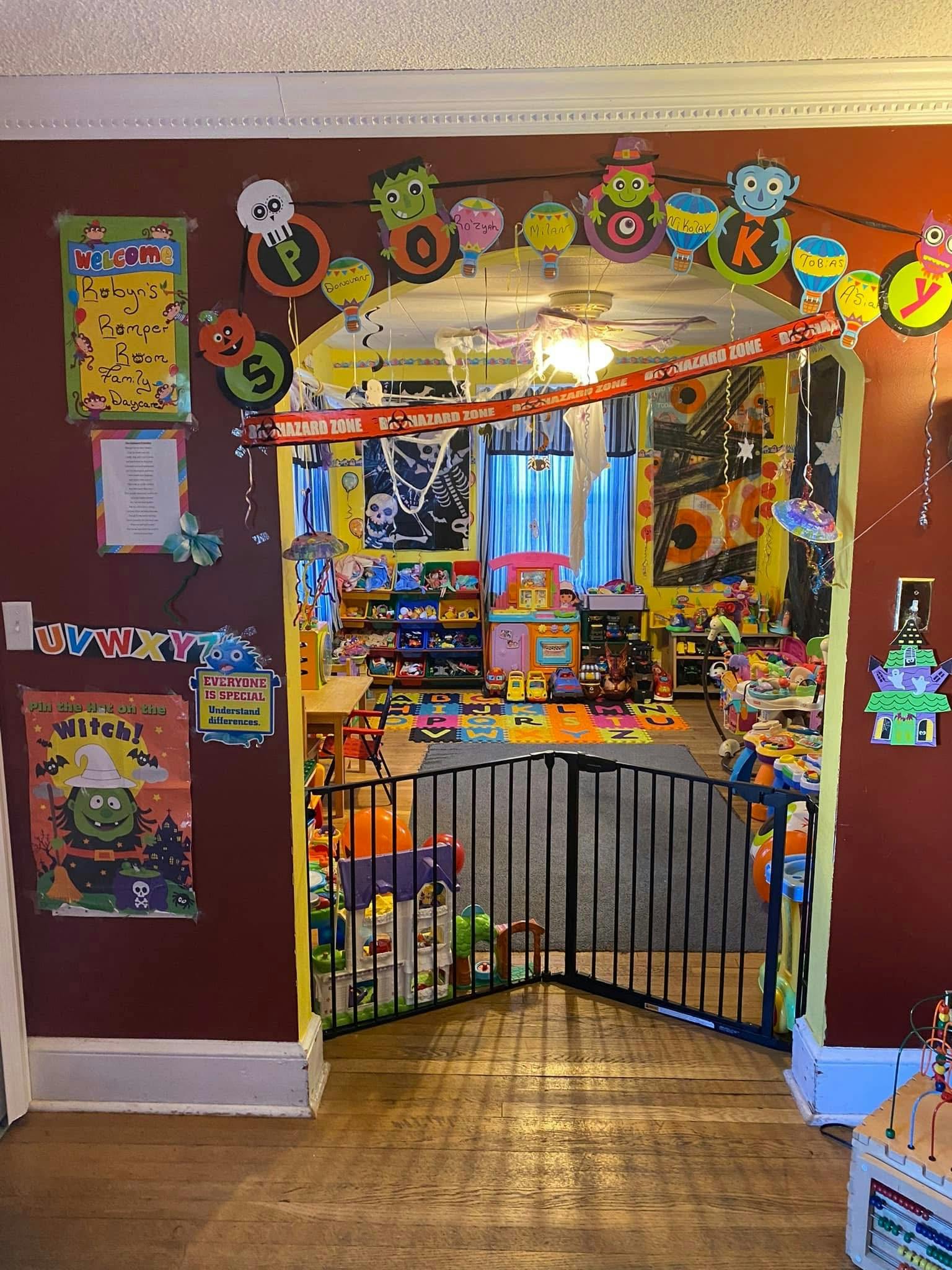 Doorway decorated with Halloween garland leading to a playroom with a baby gate