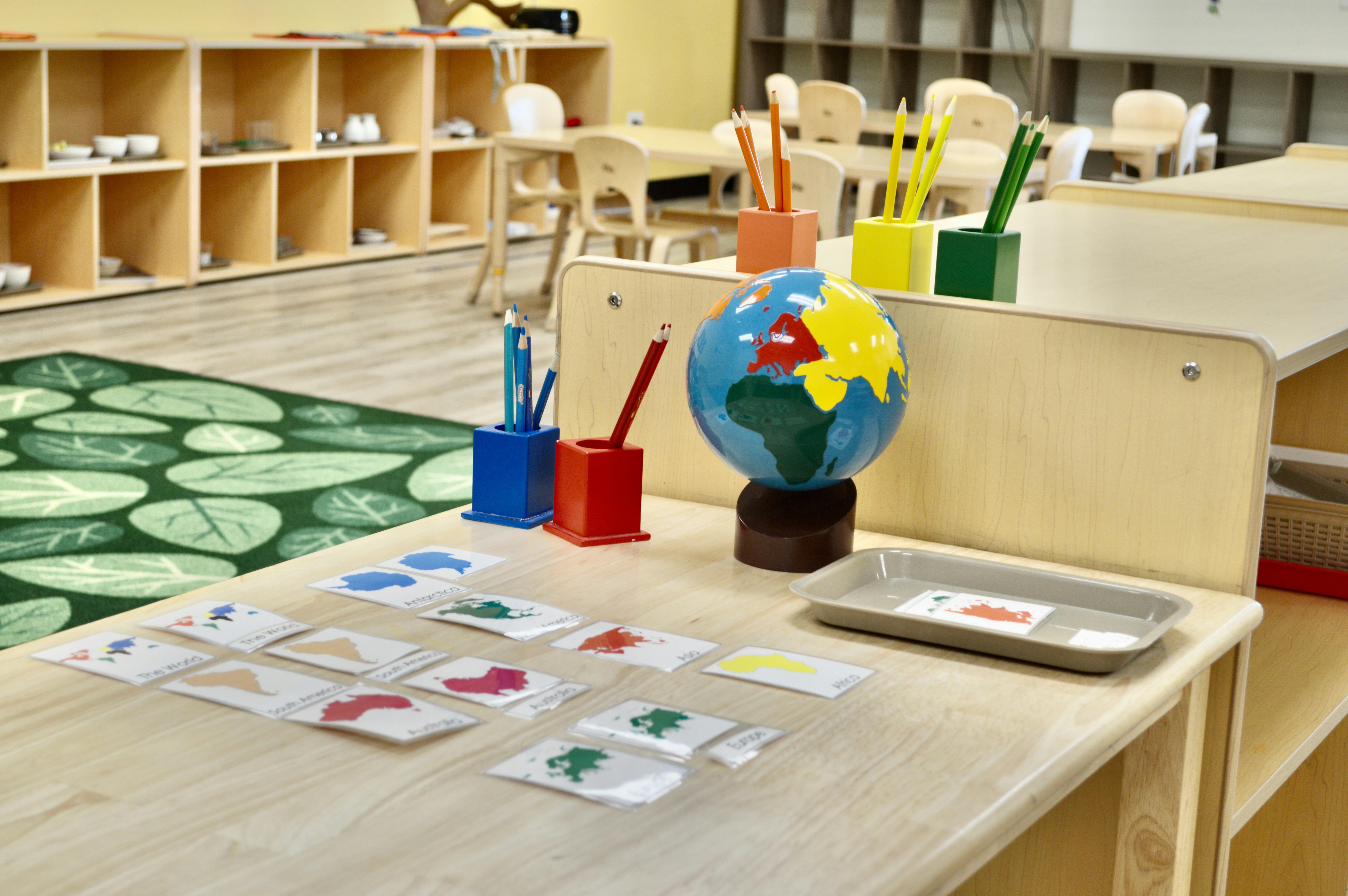 Classroom with a globe, pencils, and learning cards on a table
