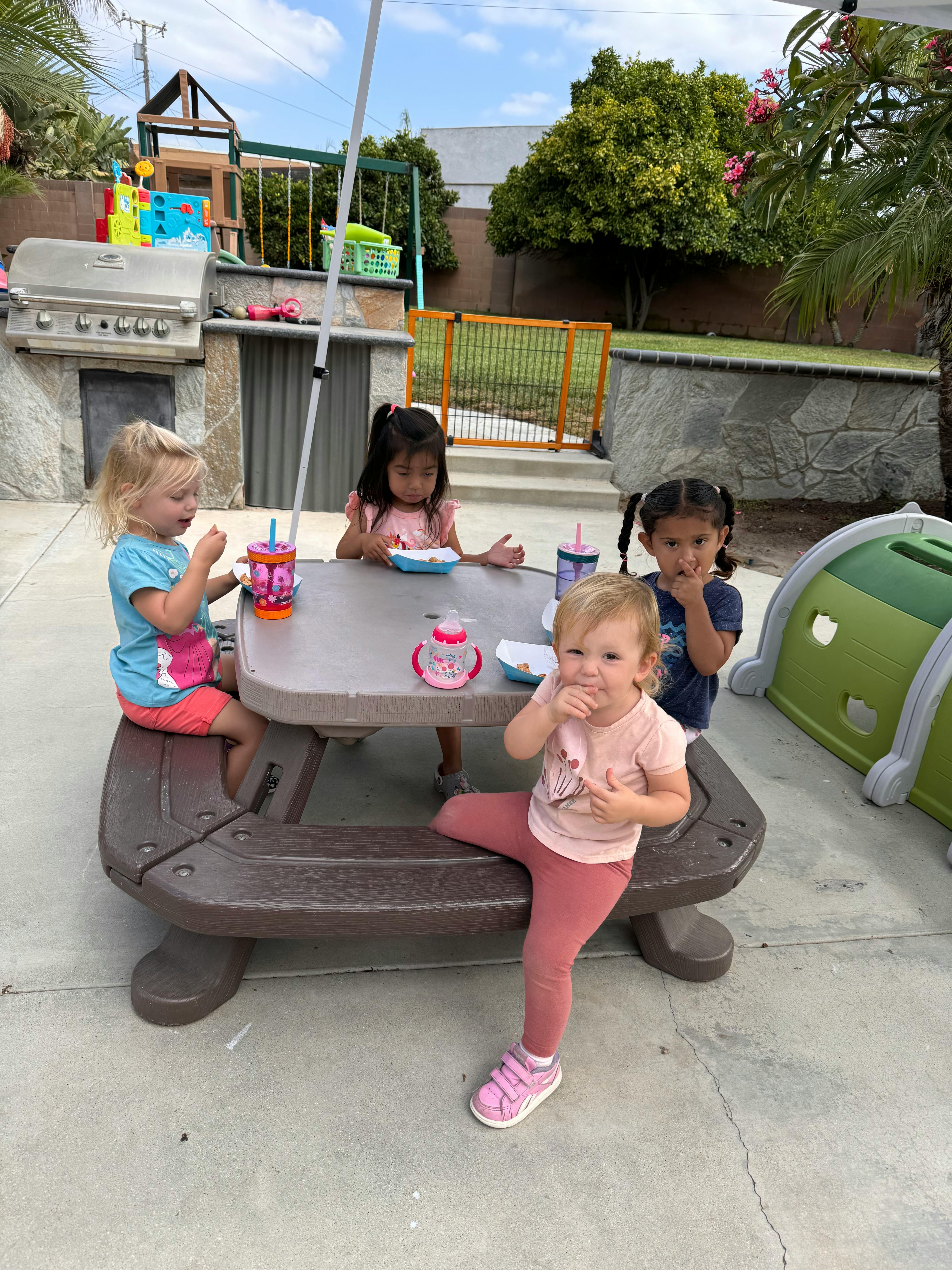 Children eating at a picnic table outdoors