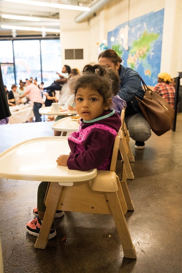 Child sitting in a high chair looking forward