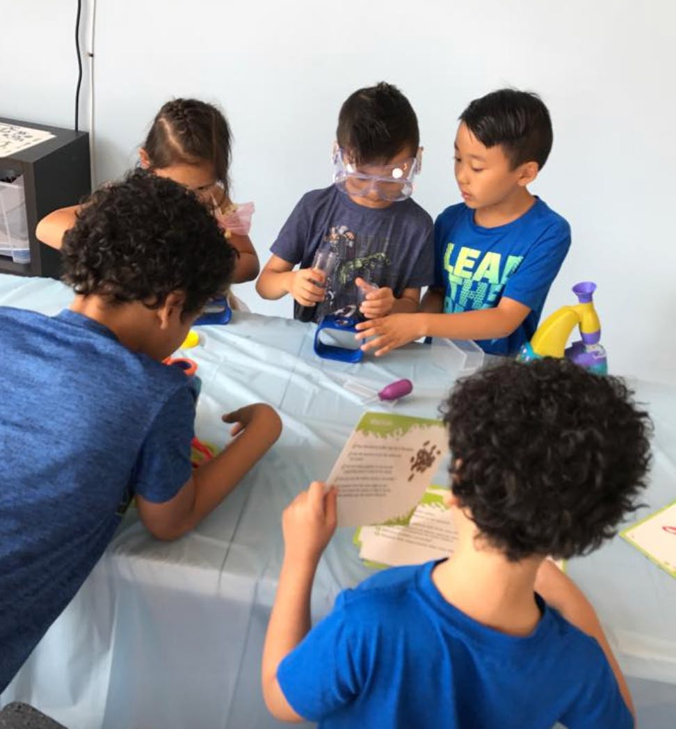 Children at a table doing a science activity with microscopes
