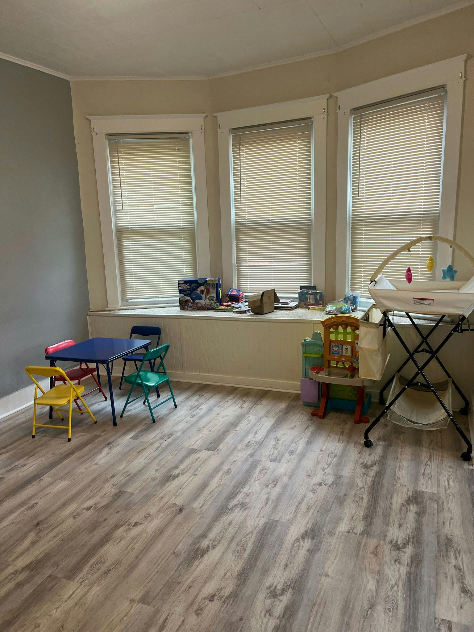 Children's table and chairs with a baby changing station in a room