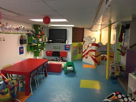 Playroom with red table, television, and play structures