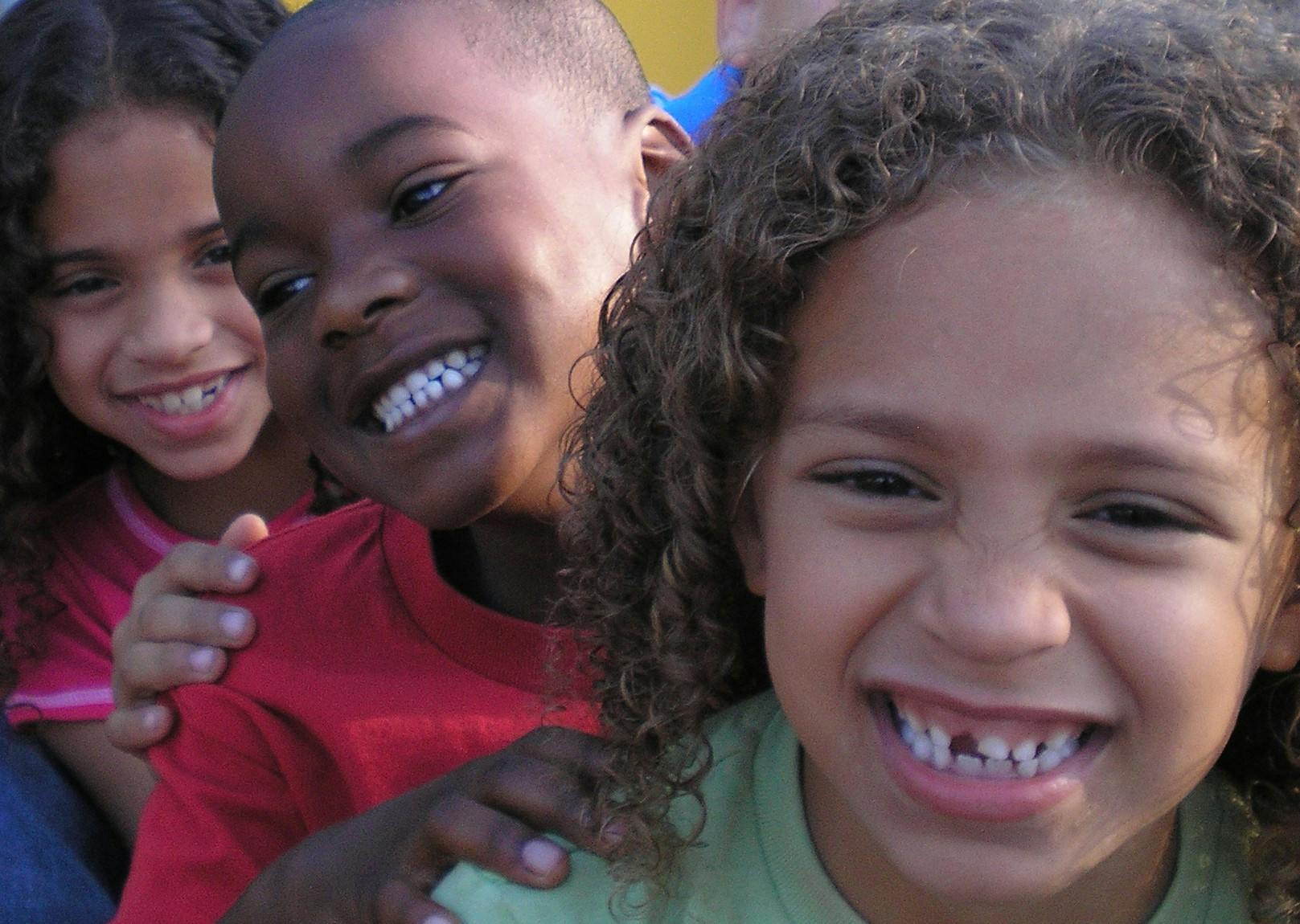 Three laughing children looking at the camera