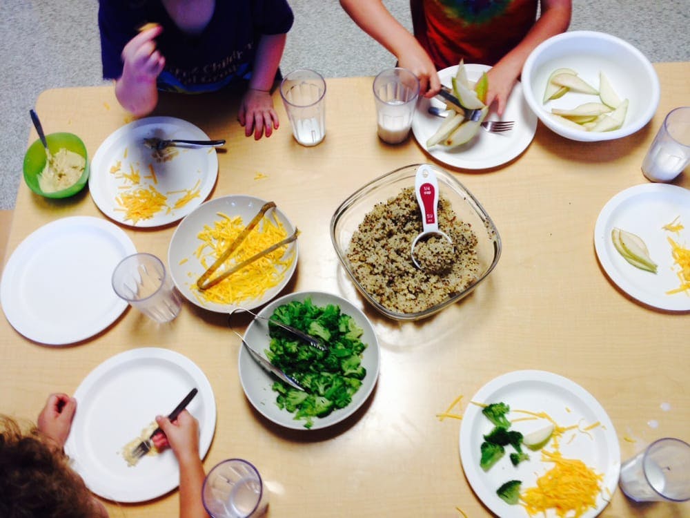 Children at a table with plates and bowls of food