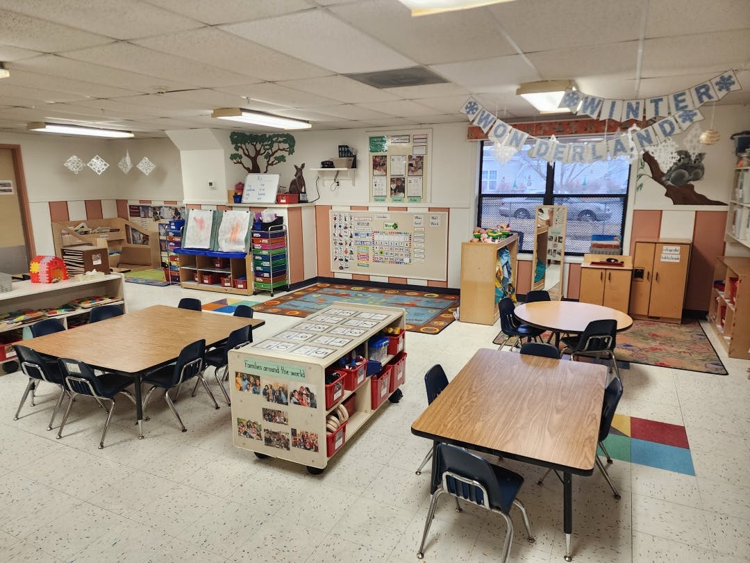 Classroom with small tables and chairs, shelves, and decorations including 'Winter Wonderland'