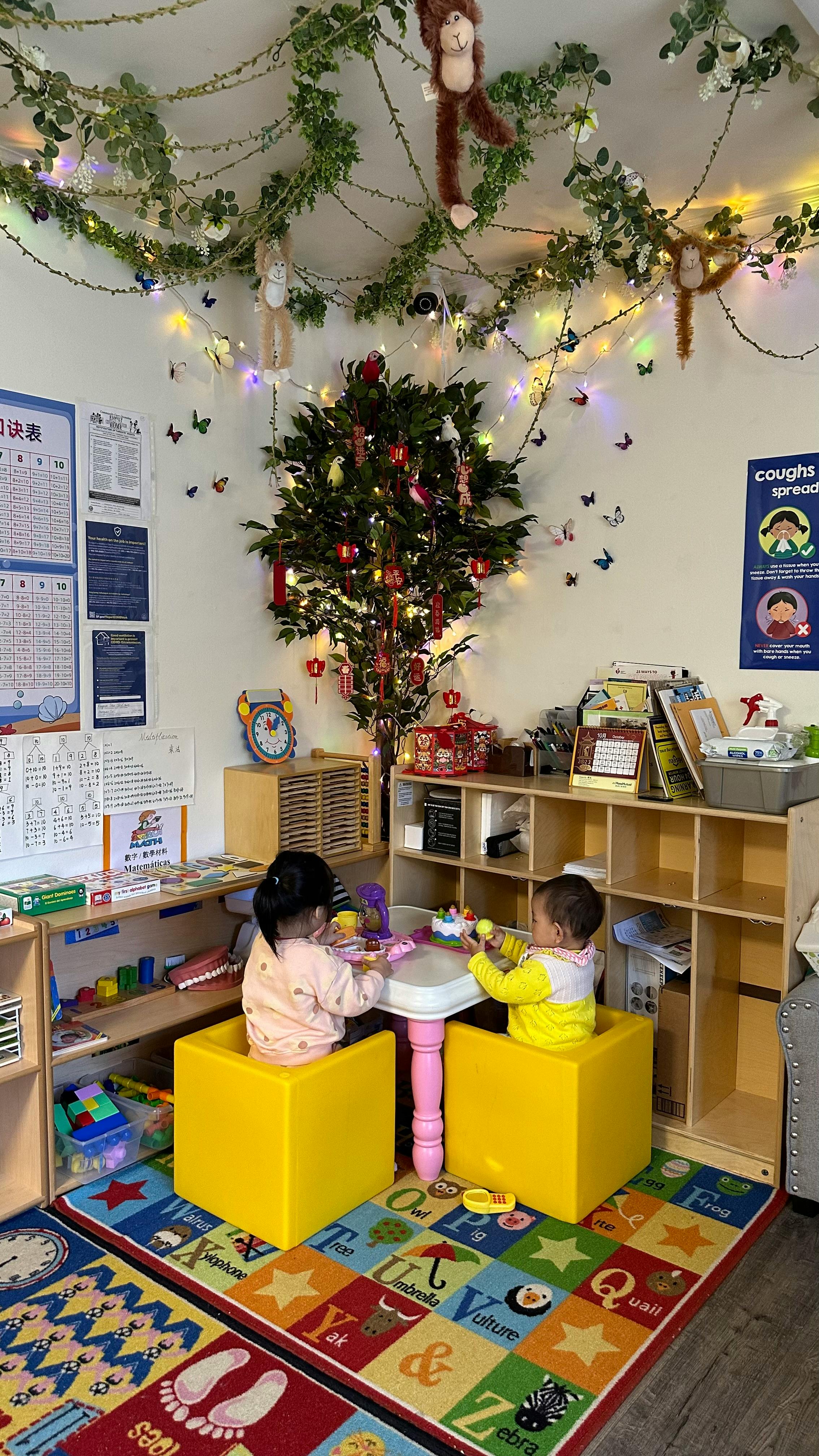 Two children playing at a small table in a classroom
