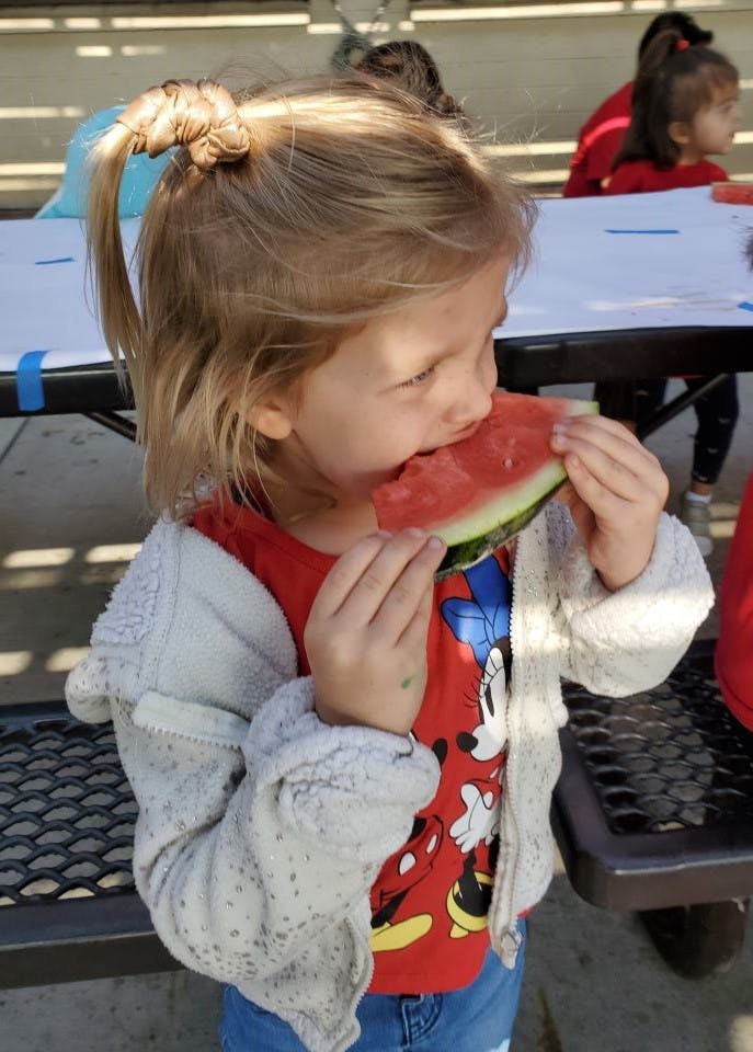 Child eating a slice of watermelon