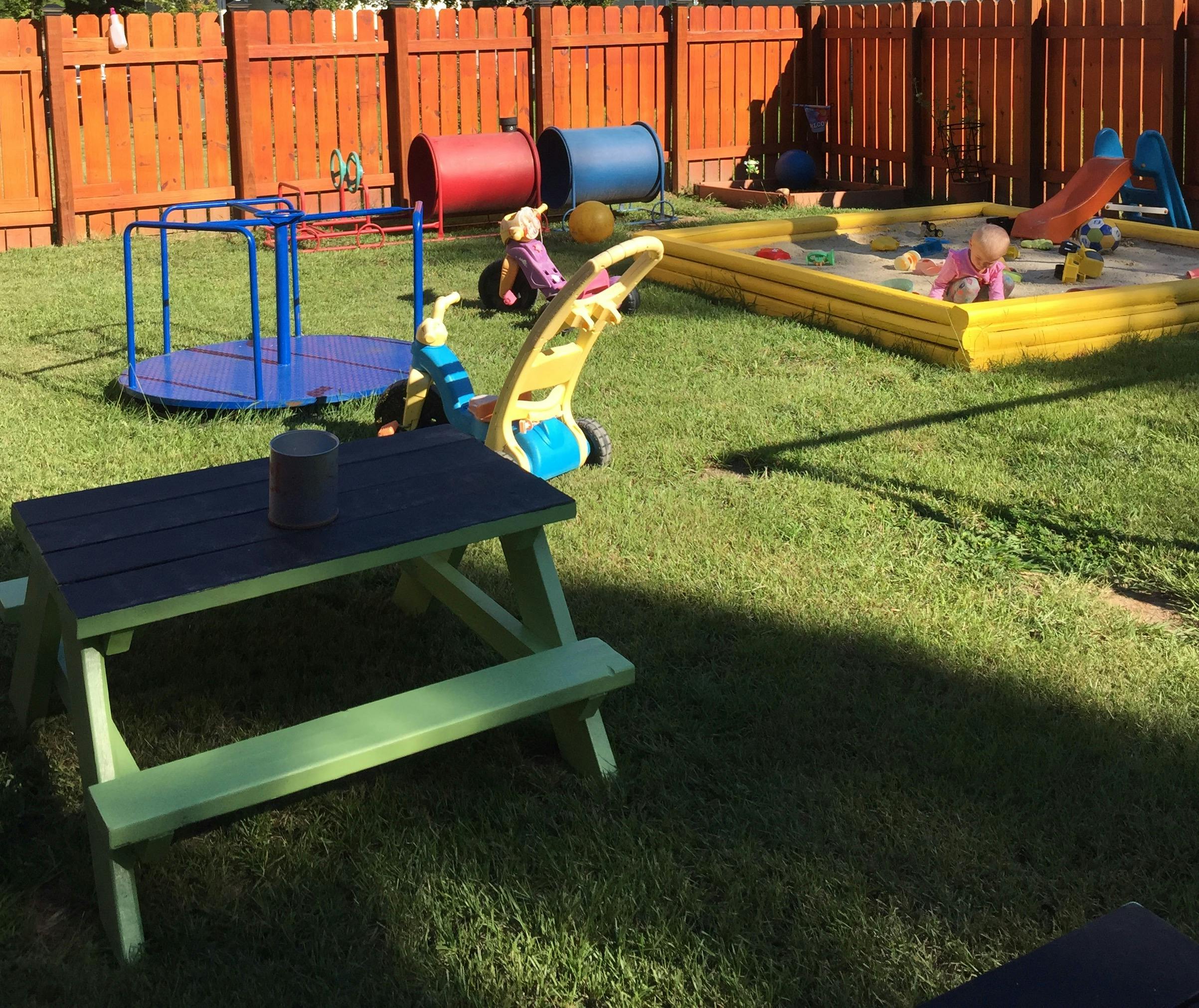 Playground with a picnic table, merry-go-round, and sandbox