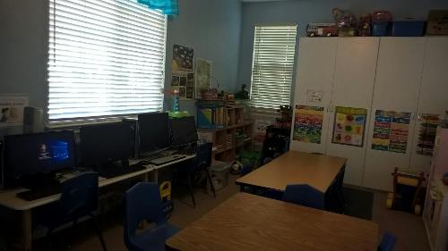 Classroom with computers, desks, and storage cabinets