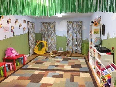 Playroom with a colorful rug, small tables, and toys