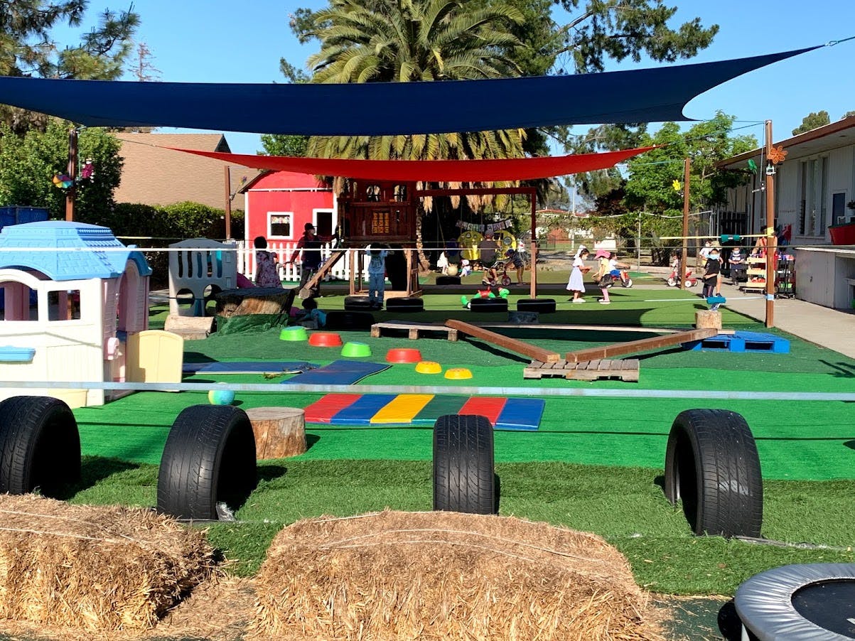 Outdoor playground with various play equipment and children