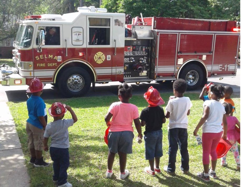Children in front of a fire truck with "Selma Fire Dept" on the side