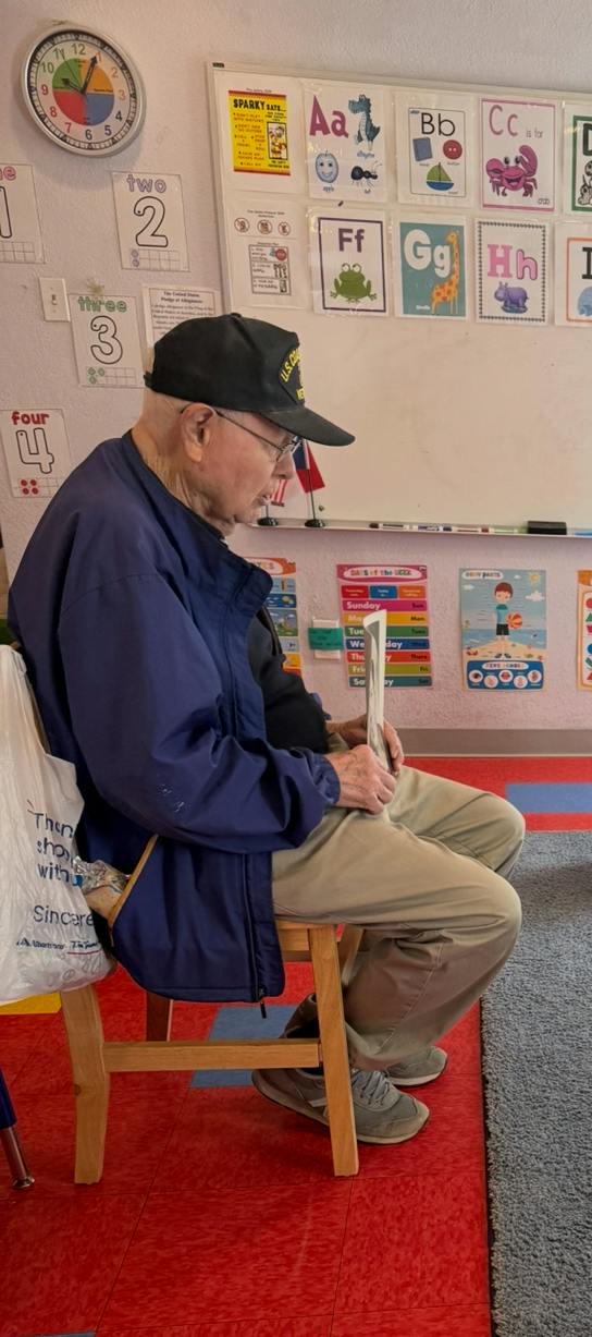 Person in a cap reading a paper while sitting in a classroom