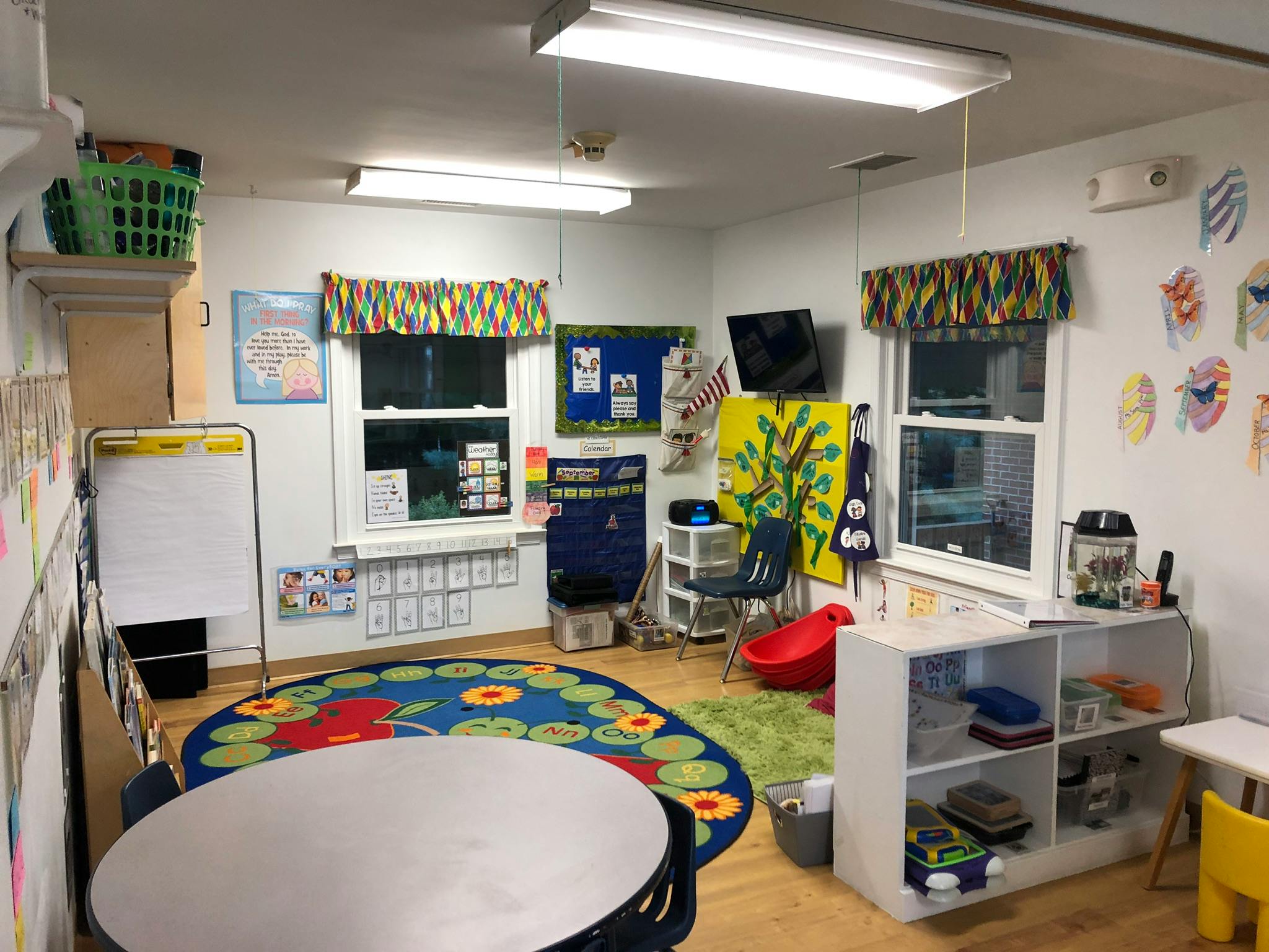Classroom with tables, chairs, and colorful rugs