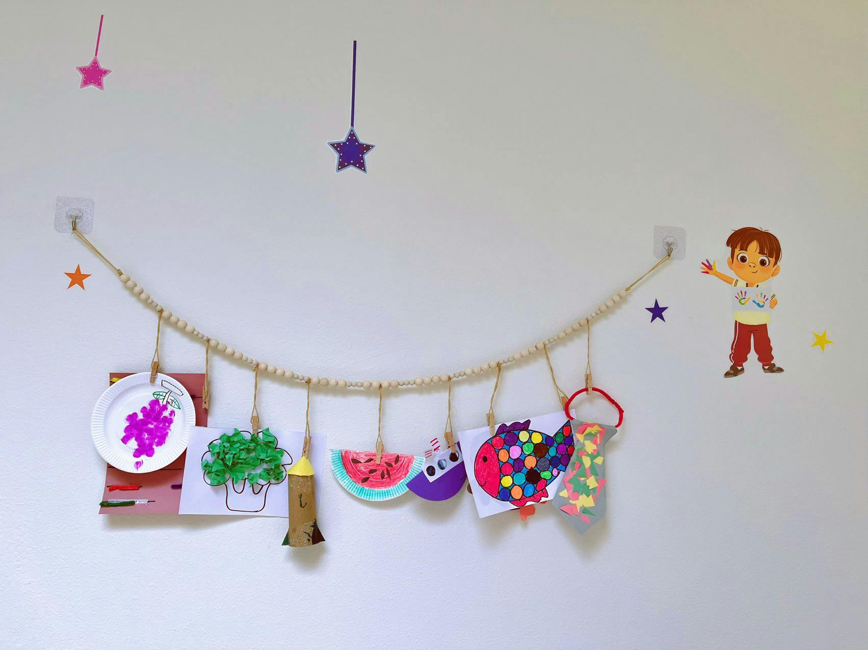 Children's artwork hanging on a string across a wall