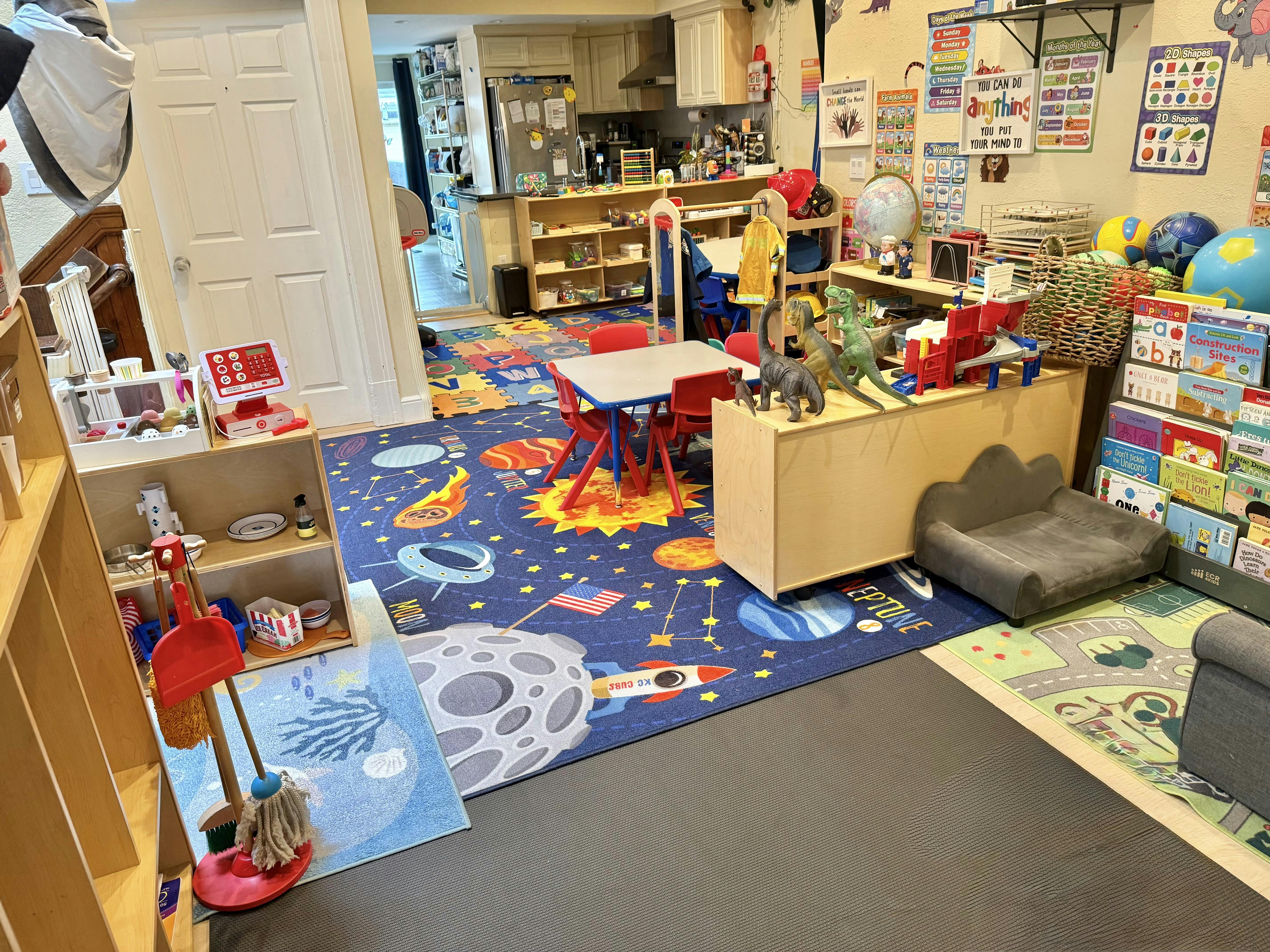 Playroom with space-themed rug, small table and chairs, and toys