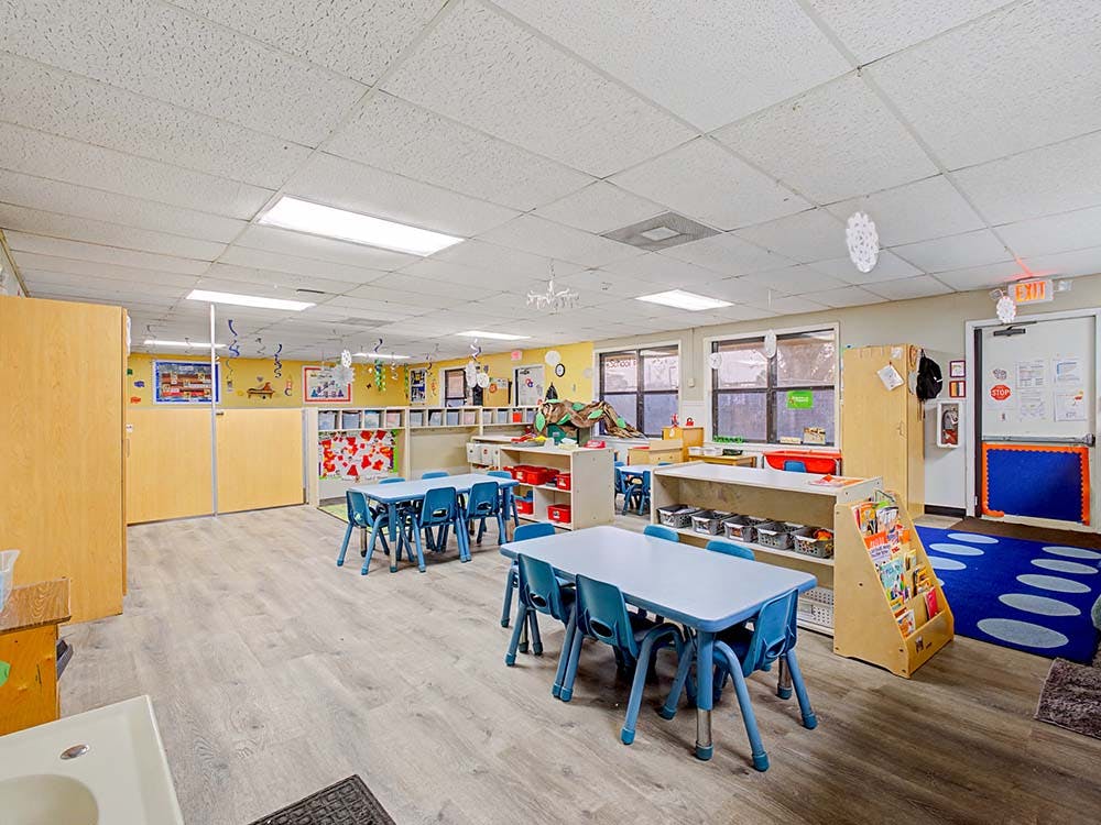 Empty colorful classroom with small tables and chairs