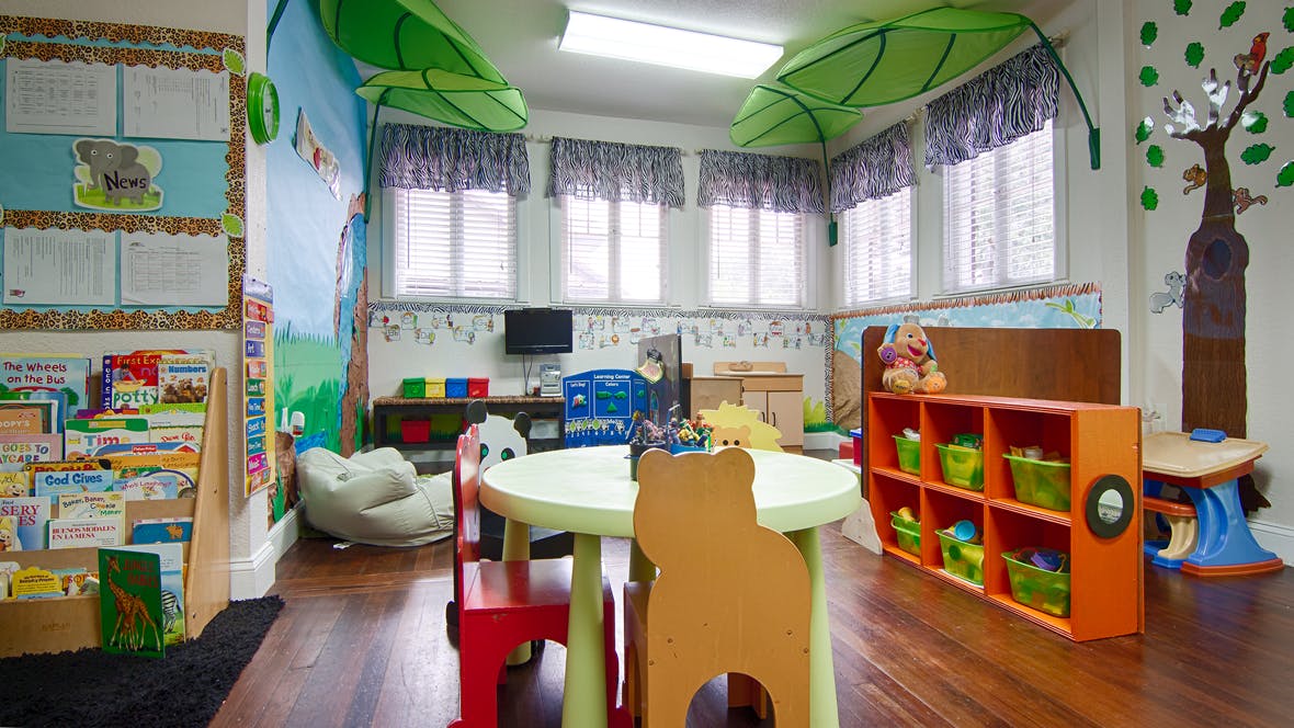 Colorful classroom with small tables, chairs, and bookshelves