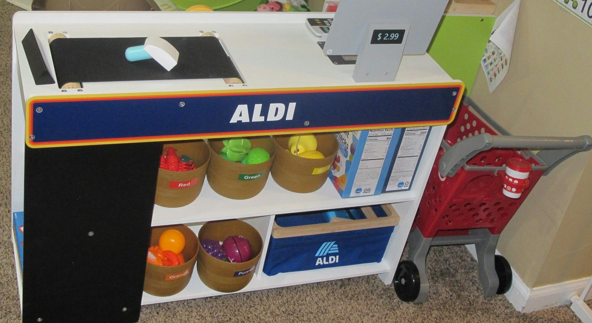 Toy grocery store checkout with shopping cart