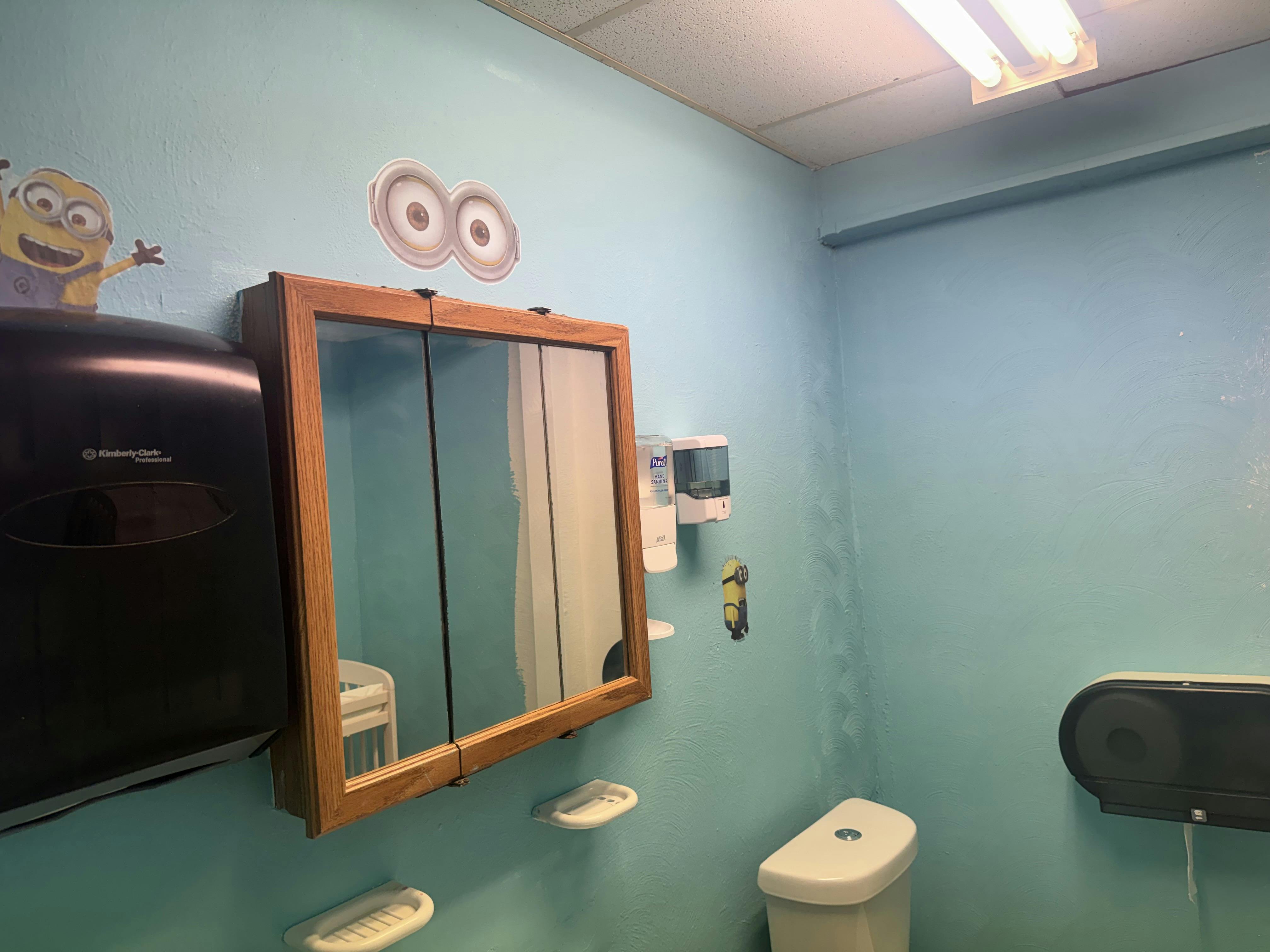 Restroom with light blue walls and Minion decorations