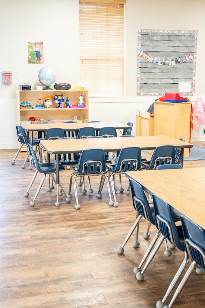 Empty tables and blue chairs in a classroom