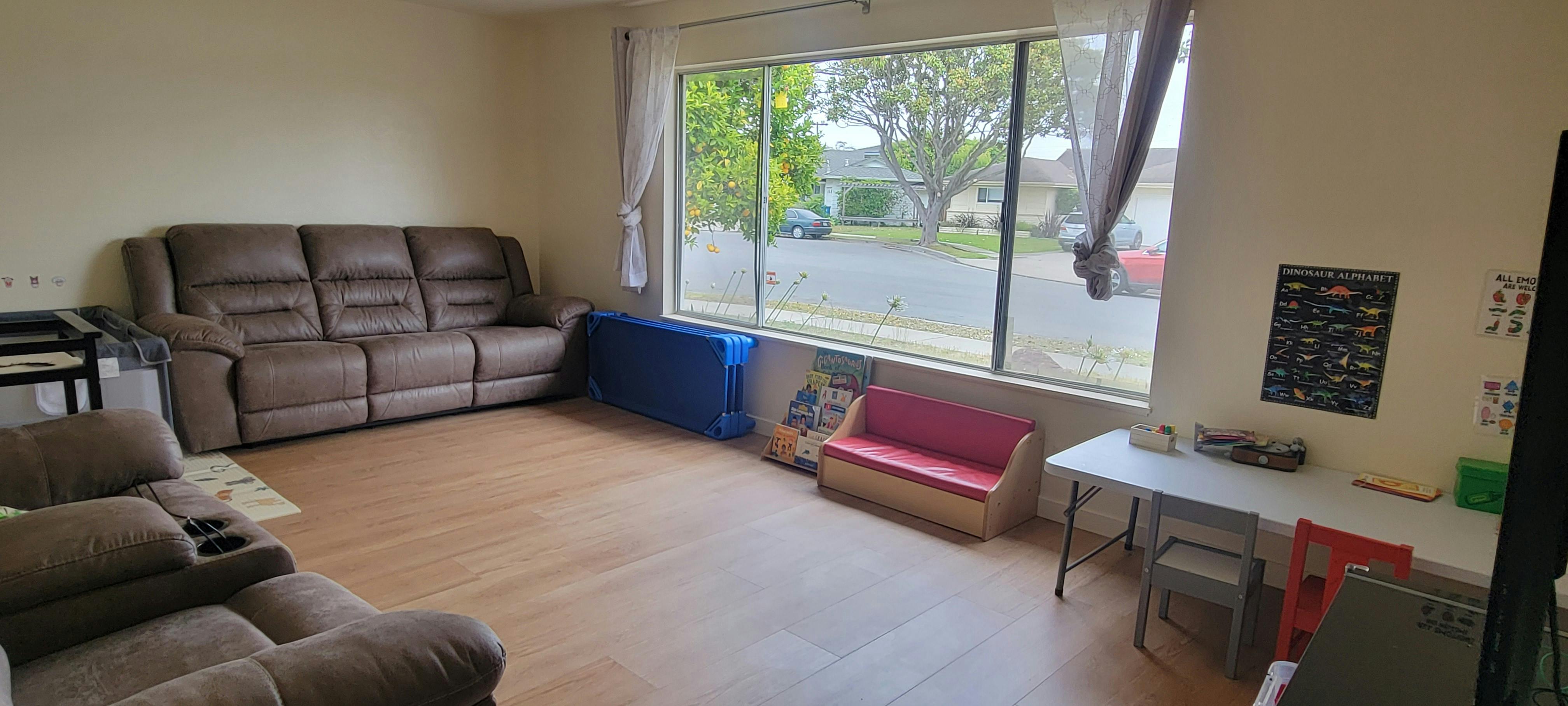 Living room with couches, a window, and a children's play area
