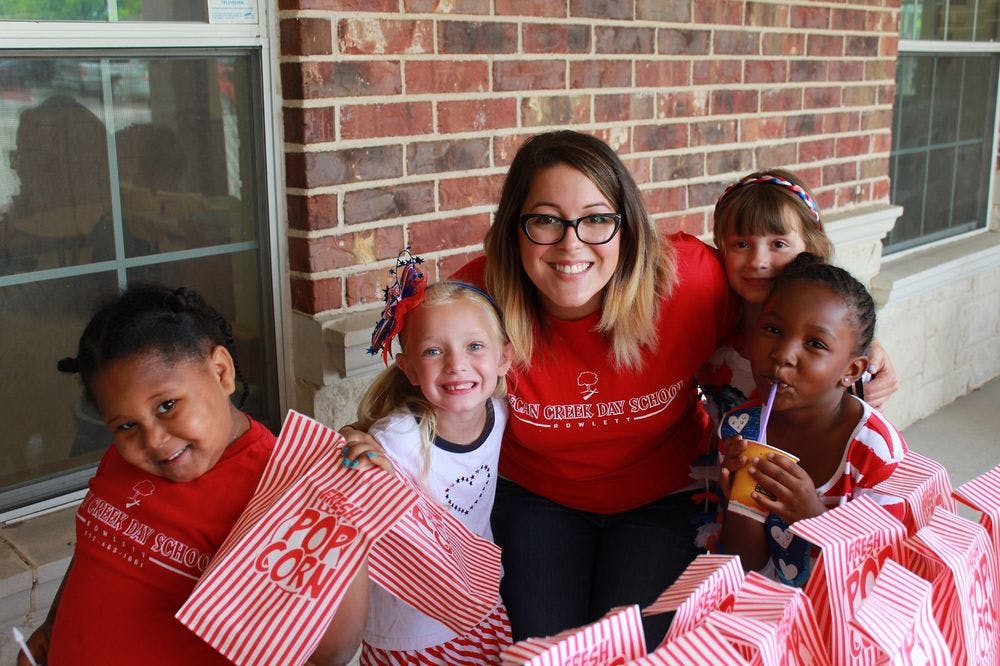 Adult and three children holding popcorn bags
