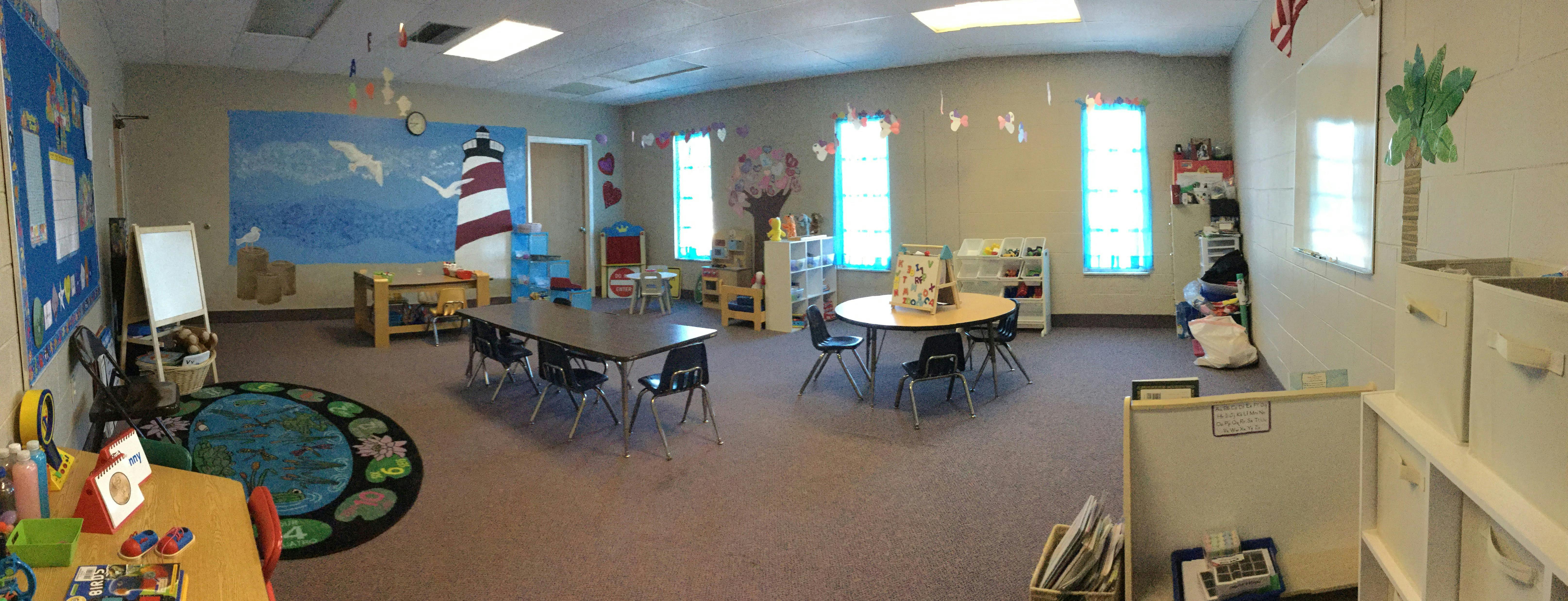Classroom with tables, chairs, and a lighthouse mural