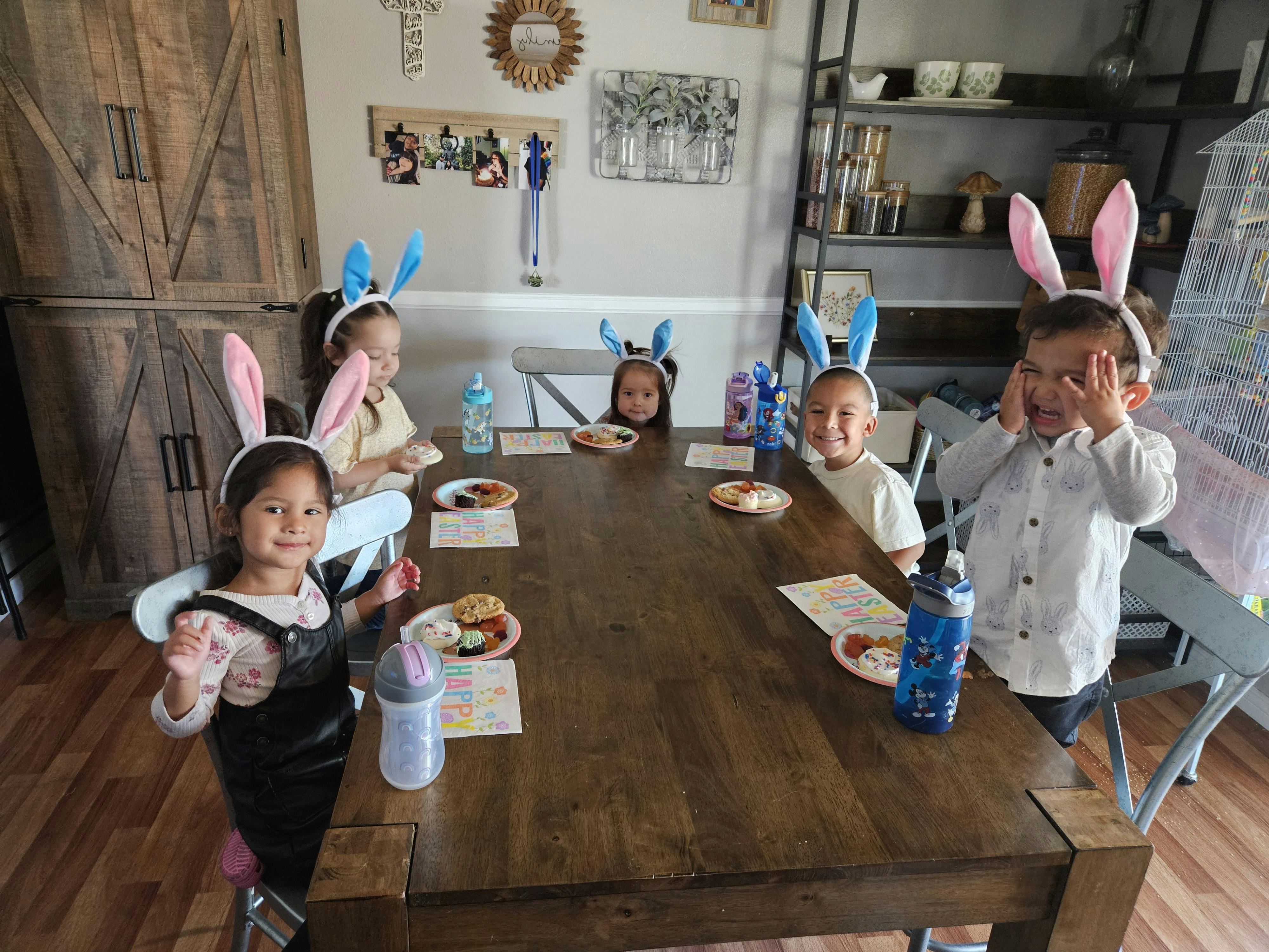 Children wearing bunny ears sitting around a table