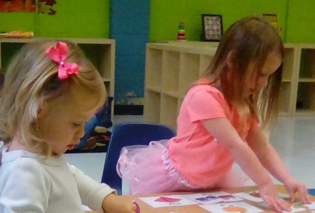 Two children at a table in a classroom
