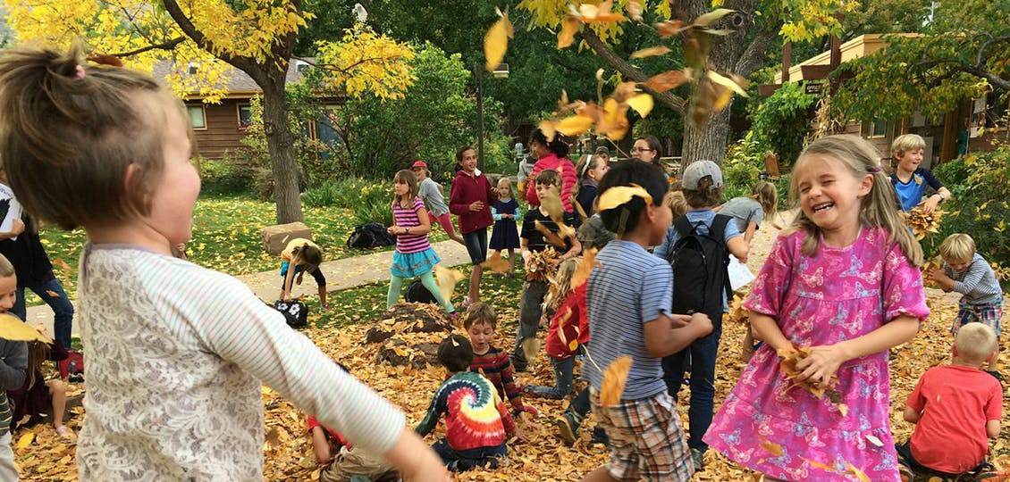 Children playing outdoors with fallen leaves