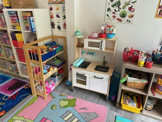 Play kitchen and shelves with toys in a room for children