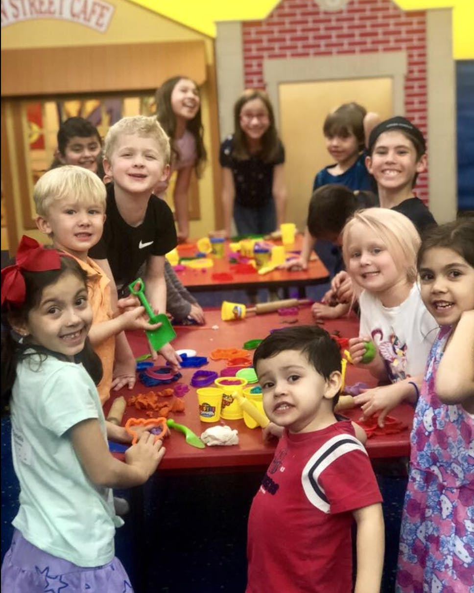 Group of children playing with modeling clay at a table