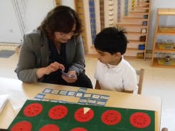 Adult and child at a table with learning materials
