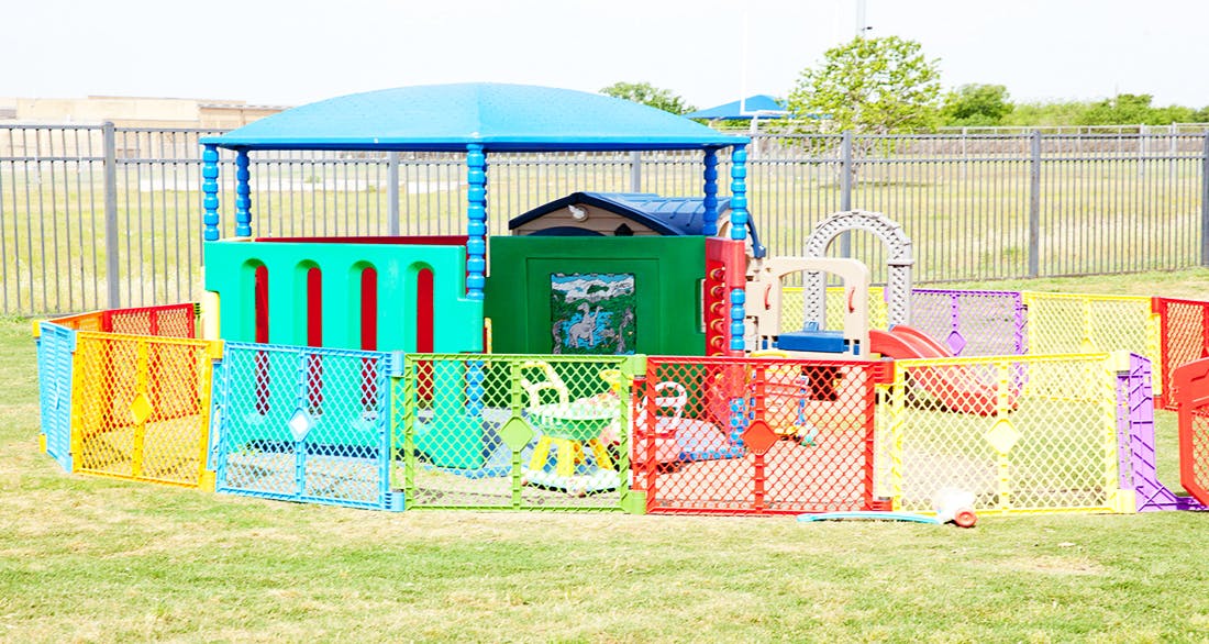Outdoor play area with colorful fences and play structures