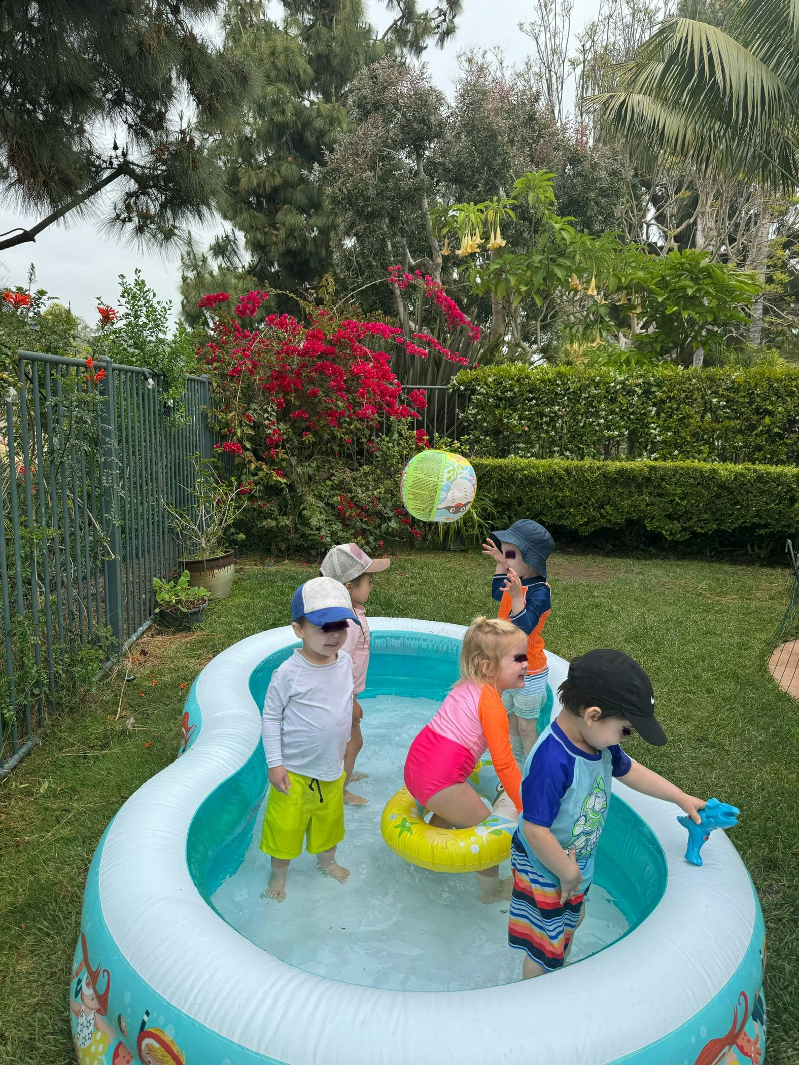 Children playing in an inflatable pool with a beach ball