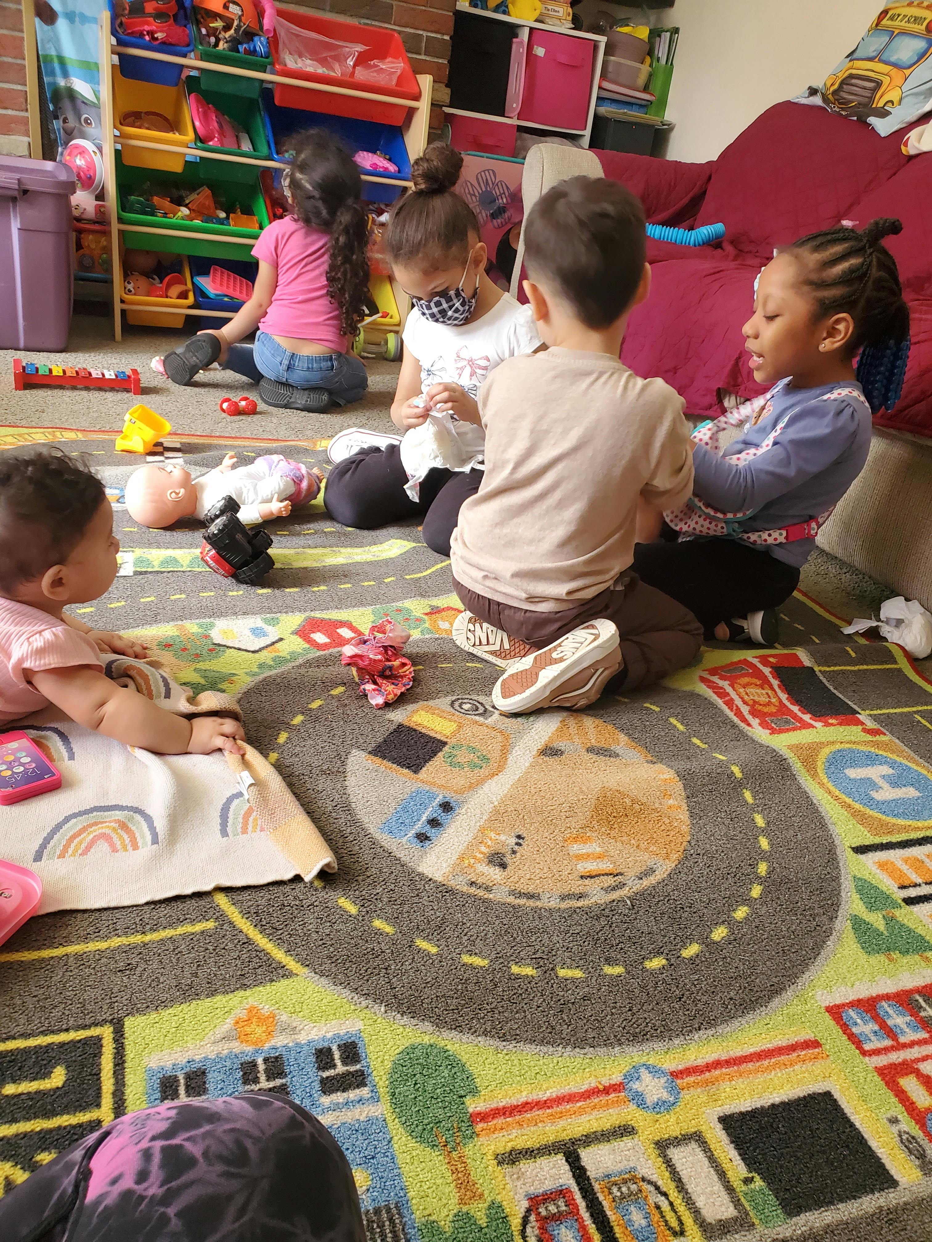 Several children playing with toys on a patterned rug