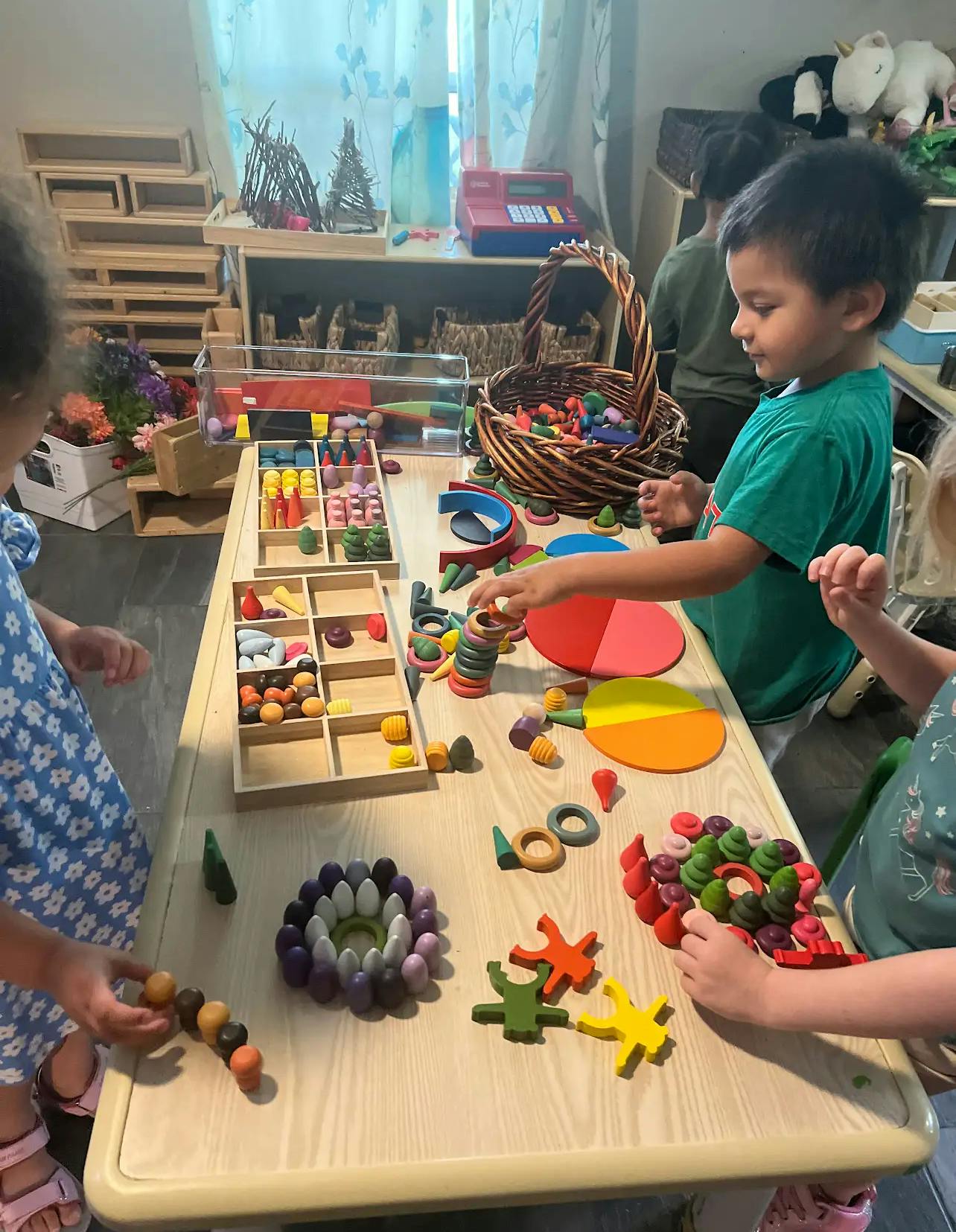 Children playing with colorful wooden toys at a table