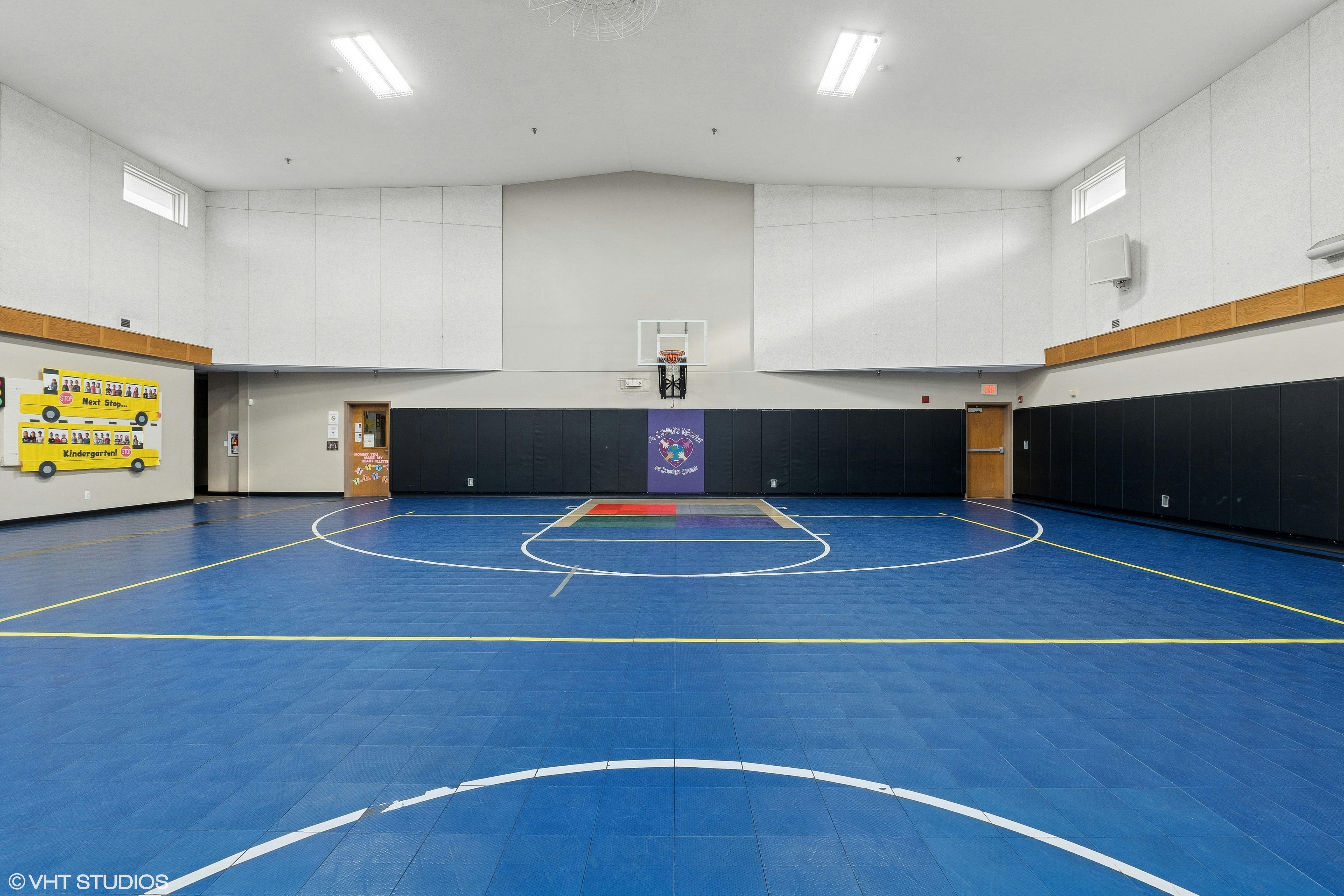 Indoor basketball court with blue floor and white lines