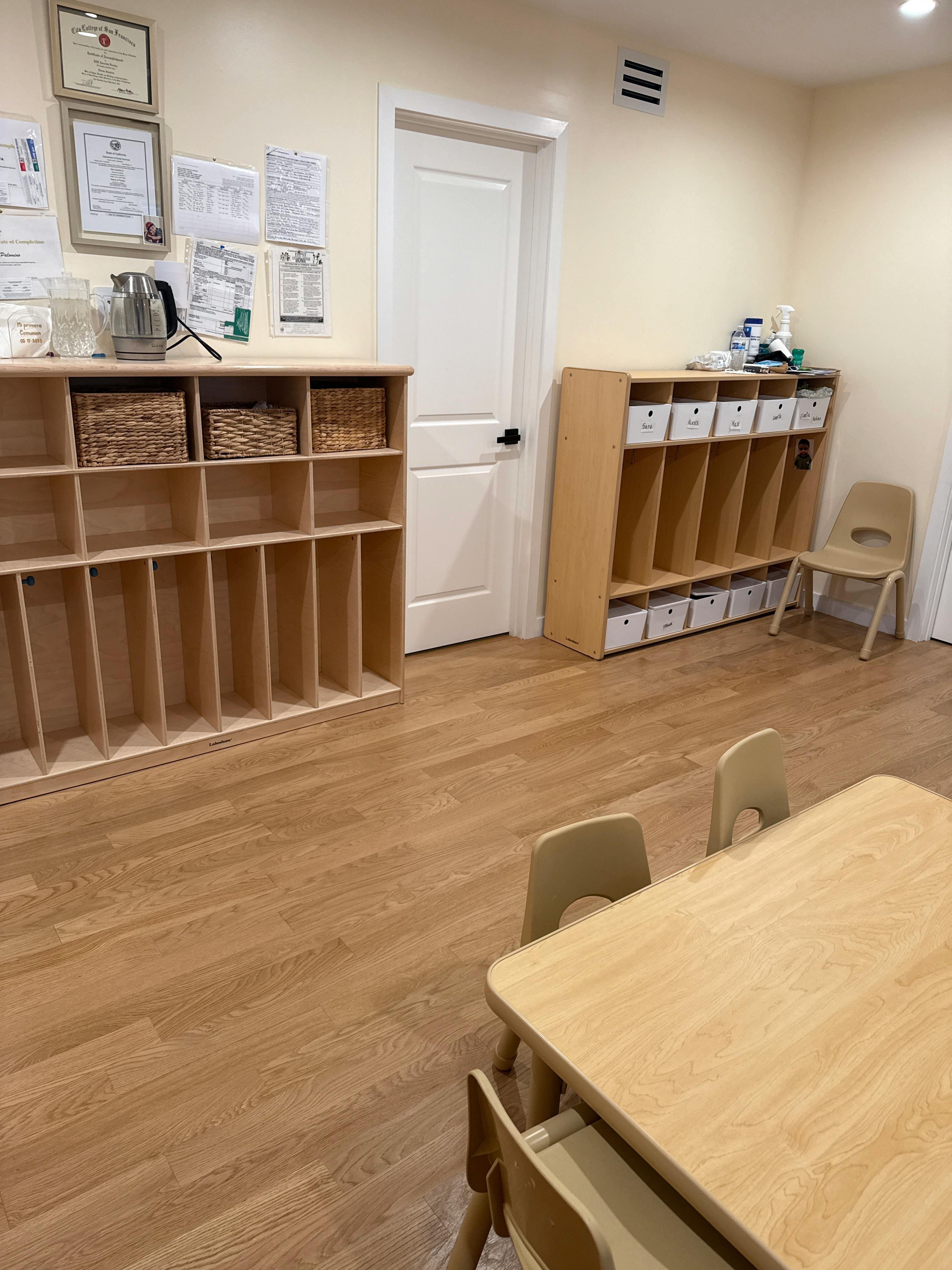 Classroom with wooden shelves, small table, and chairs