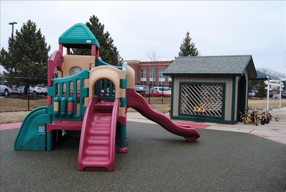Playground with climbing structure, slides, shed, and small tricycles